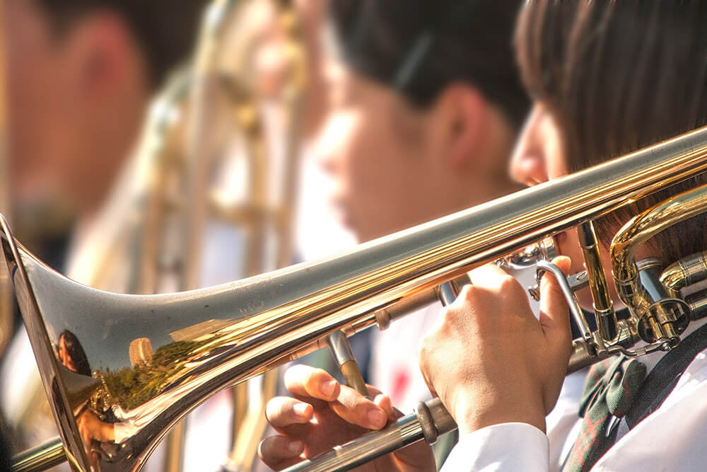 ブラスバンドでトロンボーンを吹く学生